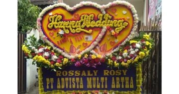 Papan bunga happy wedding terpasang di gedung pernikahan